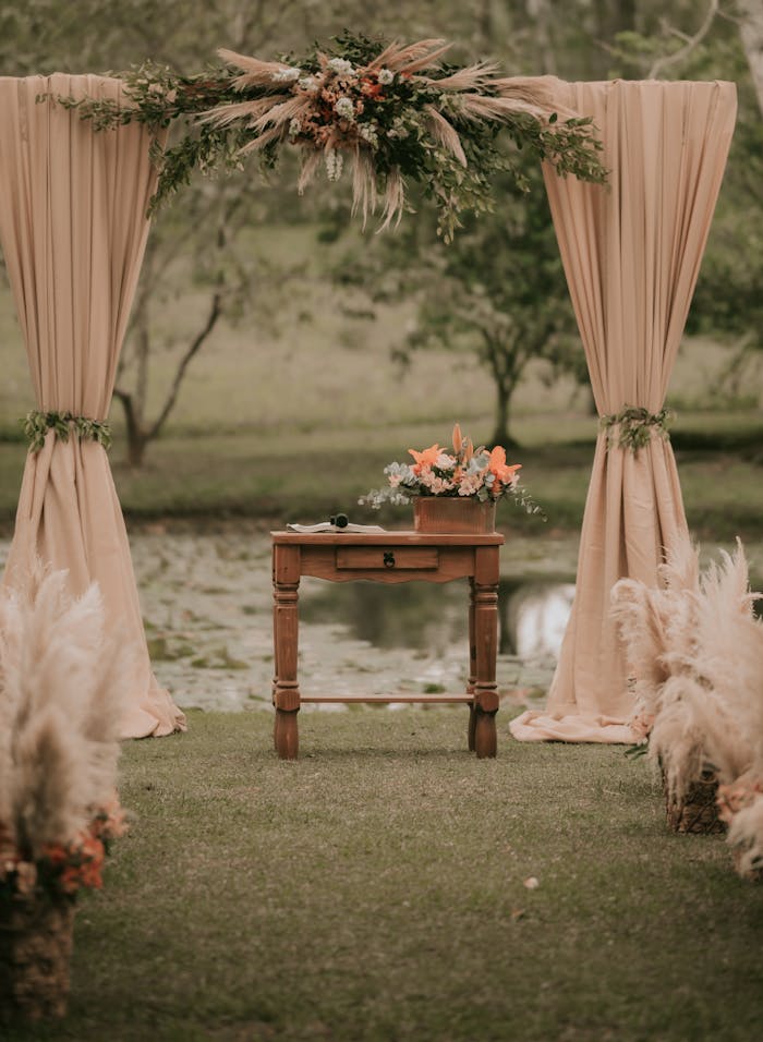 Beautiful rustic wedding altar setup by a pond with natural decorations.